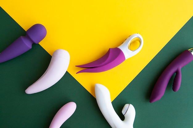 Verzameling van verschillende soorten seksspeeltjes op een groene en gele achtergrond seksspeeltjes voor volwassenen dildo's vibrators clitorisstimulatoren