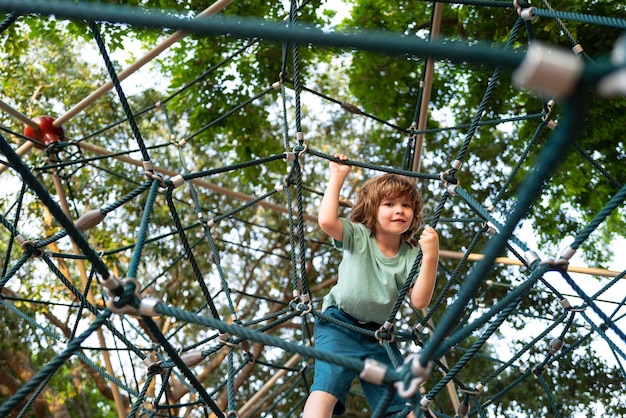 Verzekering kinderen Kleine jongen klimmen op het touw op speelplaats Gezondheidszorg concept voor familie en kinderen medische gezondheidszorg bescherming