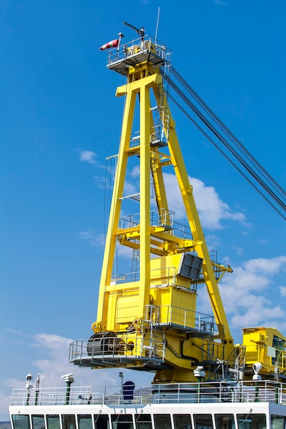 Vessel with a crane on a surface of blue sky in Kamchatka