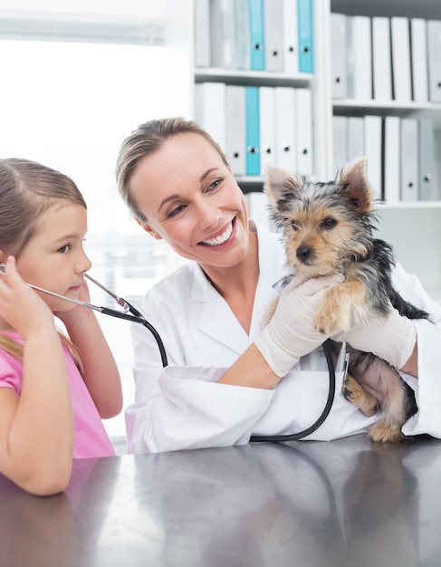 병원에서 강아지를 검사하는 여자와 수 의사