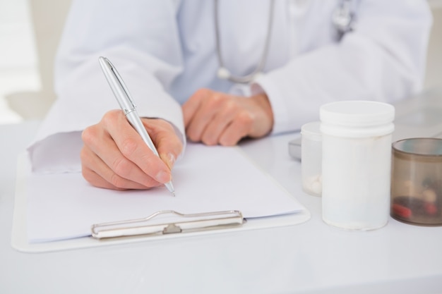 Vet writing on clipboard the prescriptions