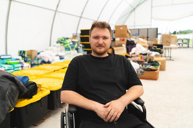 A veteran disabled man in a wheelchair helps in a humanitarian unit support of war victims