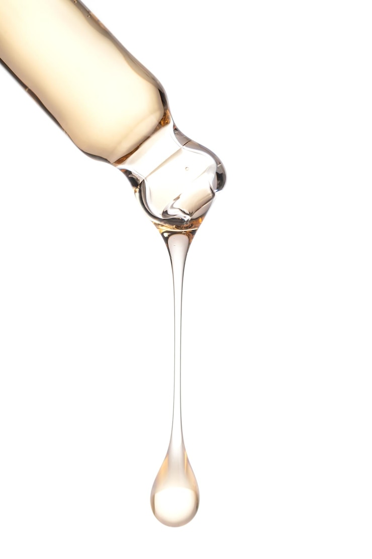 Foto vette druppel druipt van pipet in cosmetische fles close-up geïsoleerd op witte achtergrond huidverzorging productpresentatie
