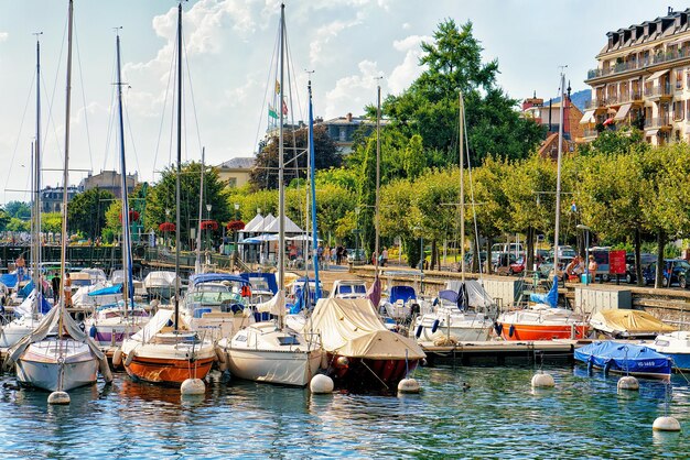 Vevey, Zwitserland - 27 augustus 2016: Boten in de jachthaven aan het meer van Genève in Vevey, kanton Vaud, Zwitserland. Mensen op de achtergrond