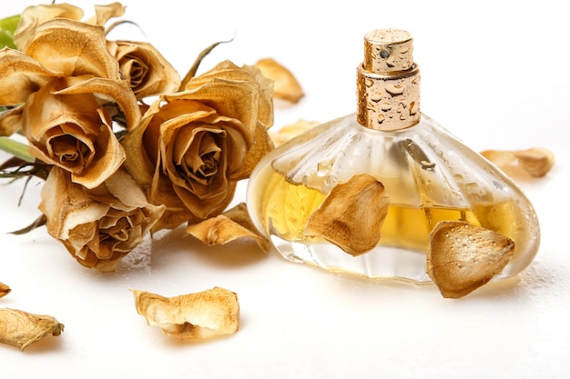 Vial of perfume and dry rose flower