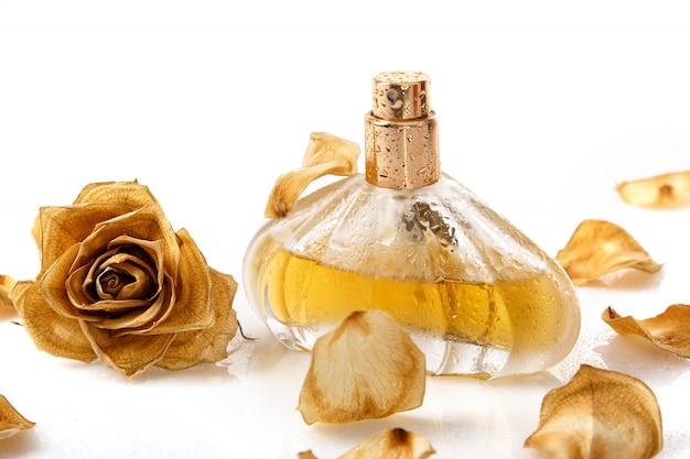 Photo vial of perfume and dry rose flower