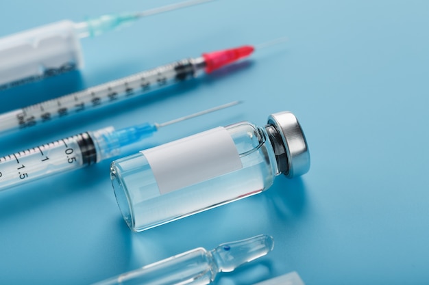 Vials of vaccine and syringes in a row