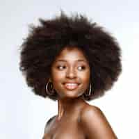 Photo a vibrant african american model with dynamic afro hair smiling isolated on a white backrop