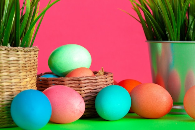 Vibrant colored eggs in a nest on green. Easter concept