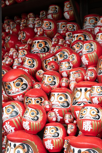 Photo a vibrant image showcasing a crowd of darumas in the streets of osaka japan a colorful and cultura