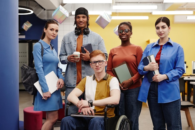 Vibrant portrait of diverse group of students in college young\
man with disability in foreground all