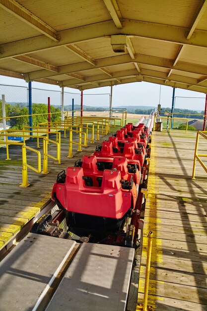 Vibrant Red Roller Coaster at Sunny Amusement Park Front View Perspective