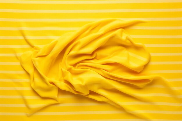 Photo vibrant striped beach towel a crumpled ode to summertime bliss top view on a yellow background