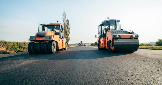 Vibratory asphalt roller compactor compacting new asphalt\
pavement road service repairs the highway