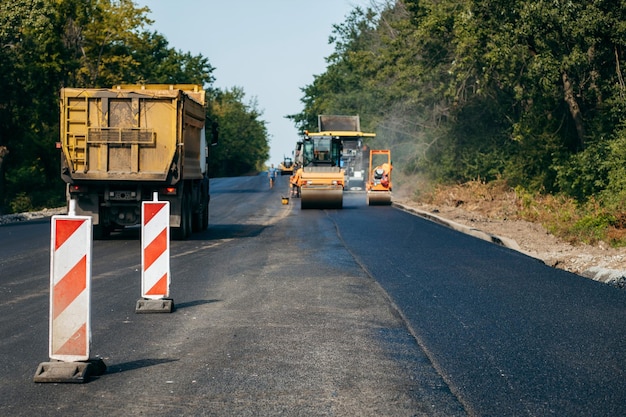 Vibratory asphalt rollers compactor compacting new asphalt pavement Road service build a new highwa