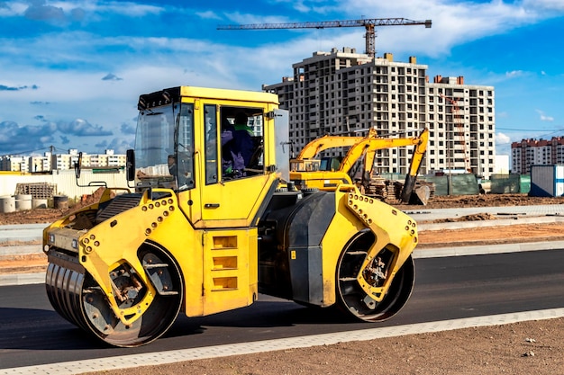 振動ロード ローラーは、建設中の新しい道路にアスファルトを敷設します 道路機械の作業のクローズ アップ 都市高速道路の建設工事