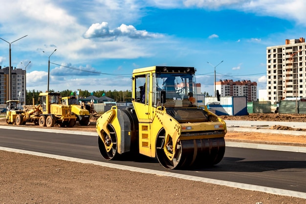 진동하는 도로 롤러는 건설 중인 새로운 도로에 아스팔트를 깔고 있습니다. 도로 기계 작업의 근접 촬영 도시 고속도로 건설에 대한 건설 작업