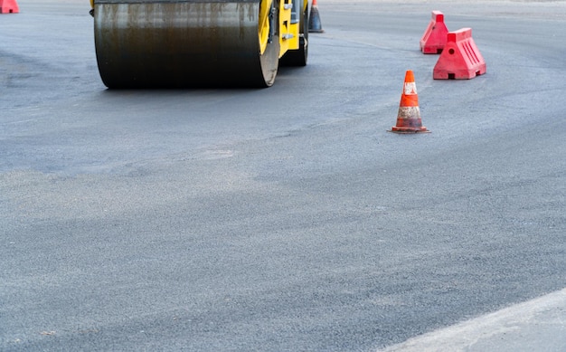 Vibratory road rollerPlastic road fencing on the road Road construction