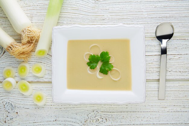 vichyssoise roomsoep met prei op wit hout