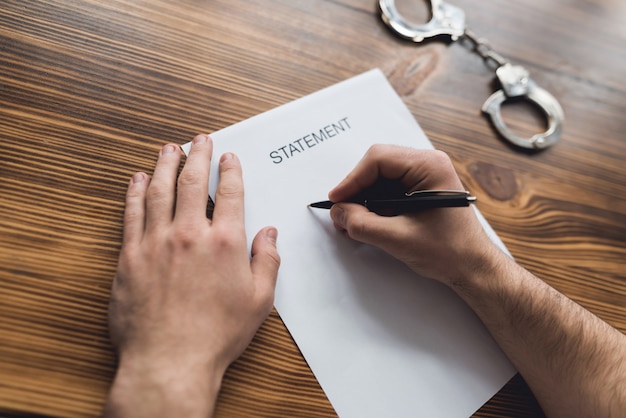 Victim of the criminal writes a statement at police station.