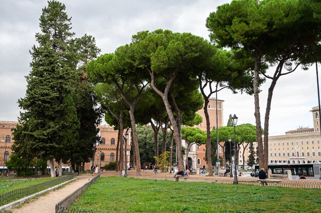 Foto il monumento a vittorio emanuele ii a roma in italia a piazza venezia, turisti e traffico automobilistico.