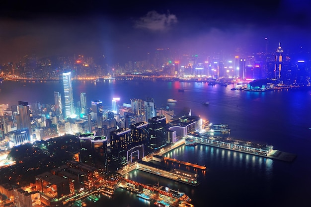 Victoria harbor aerial view with hong kong skyline and urban skyscrapers at night.