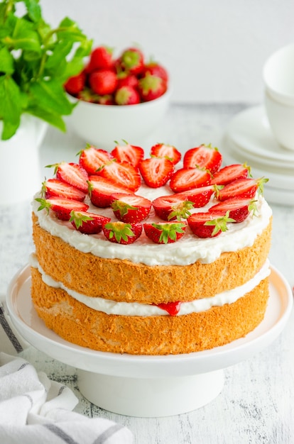 Victoria sponge cake with strawberry jam, whipped cream and fresh strawberries