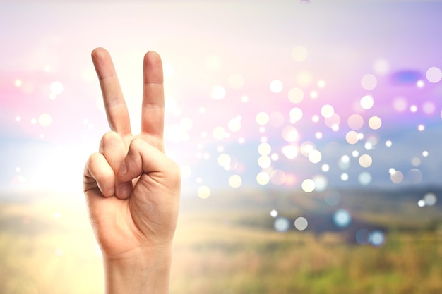 Victory fingers at countryside background