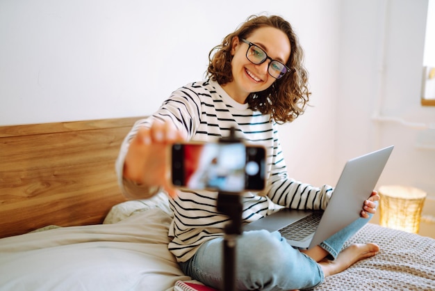 Foto video blog giovane donna che guarda nella telecamera e racconta la sua storia mentre conduce un video blog