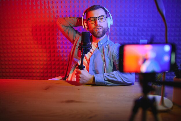 A video blogger records content in his studio the backstage\
photo was taken from behind one of the participants in the shooting\
at the beginning of the shooting when the blogger is preparing