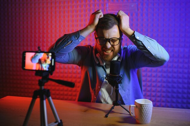 A video blogger records content in his studio the host of the video blog is a young man who is very enthusiastic about telling his subscribers a story