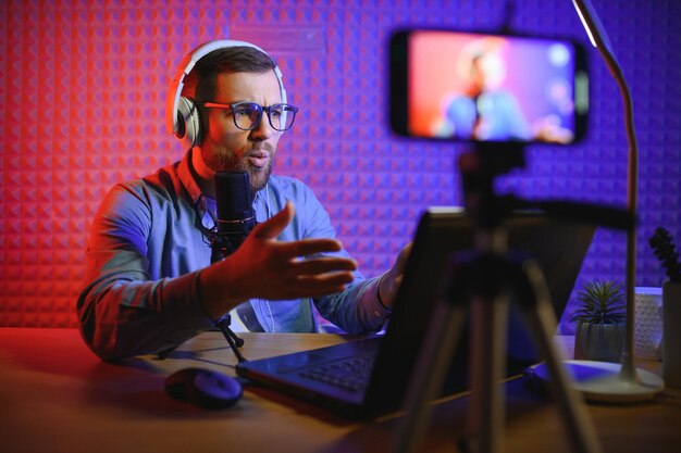 Photo a video blogger records content in his studio the host of the video blog is a young man who is very enthusiastic about telling his subscribers a story