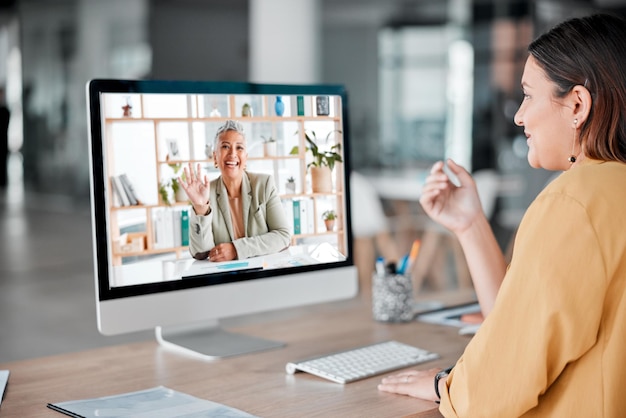 Foto videochiamate computer e donne d'affari salutano in ufficio parlando e chattando in chat virtuale comunicazione tecnologica e dipendenti o persone che salutano in webinar di riunioni online o discussioni digitali