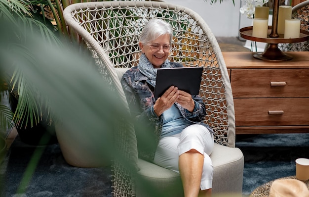 Video call concept White haired senior woman using digital tablet for online communication via video