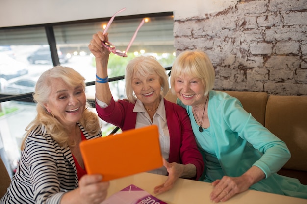 Video call. Good-looking aged ladies having a video call and looking excited