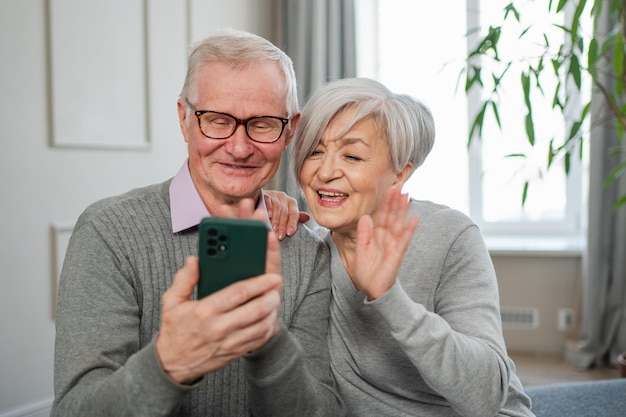 Photo video call happy senior couple woman man with smartphone having video call mature old grandmother