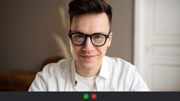 写真 ビデオ通話画面 メガネをかけた男性プログラマーがカメラ目線で微笑む