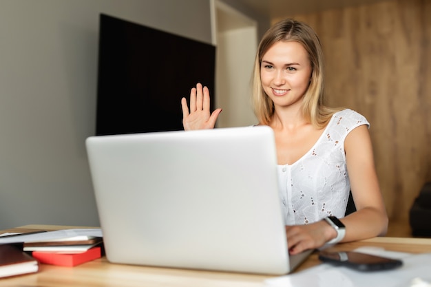 Photo video call, video conference with other people on laptop indoors. online learning and work. woman with laptop computer working at home office