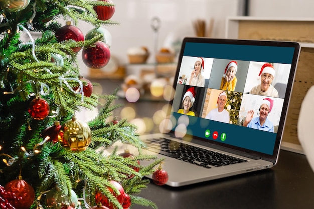 그의 작업장에서 노트북 컴퓨터로 행복한 다양한 아이들과 화상 통화를 합니다. 가정에서 자체 격리 및 가상 온라인 축하 행사. 크리스마스