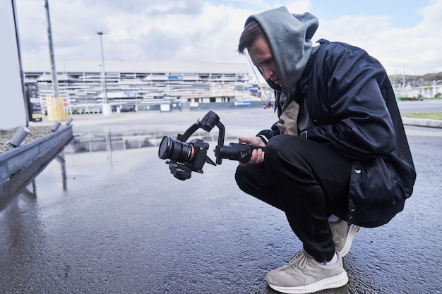 Video camera operator working with professional equipment close up