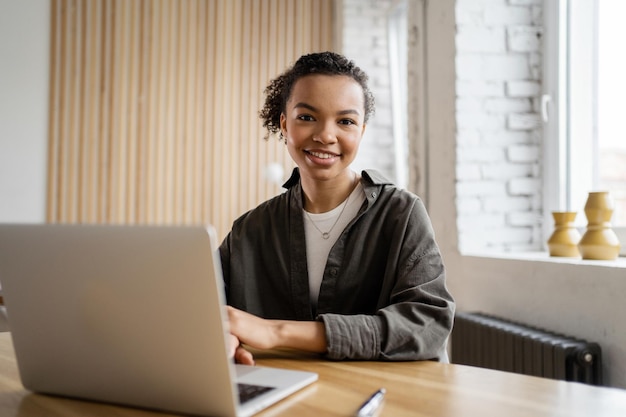 Video communication female freelancer workplace uses laptop computer company report in office