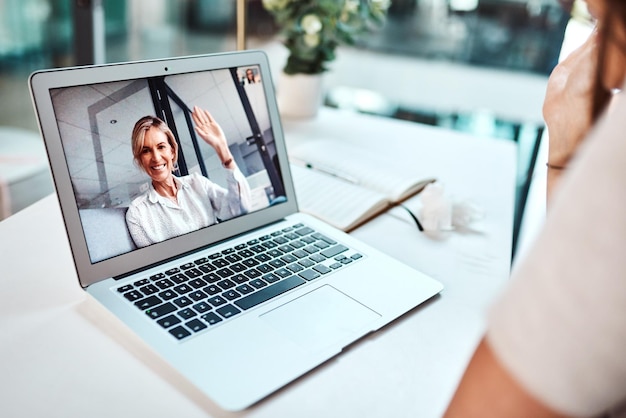 Видеоконференции открывают бесчисленные возможности для бизнеса. Снимок: зрелая женщина машет рукой, появляясь на экране ноутбука во время видеозвонка.