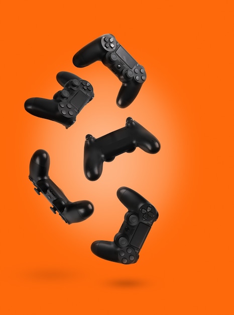 Фото Контроллеры видеоигр, изолированные на оранжевом цветном фоне
