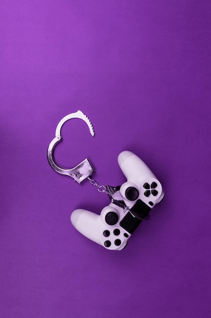 Video game joystick and handcuffs isolated. Addiction to games concept image