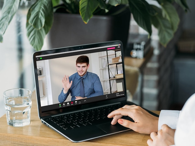 Video-interview Digitale vergadering Online communicatie Mannelijke werknemer zwaait hallo groet vrouwelijke HR-manager op laptopscherm in virtueel kantoor