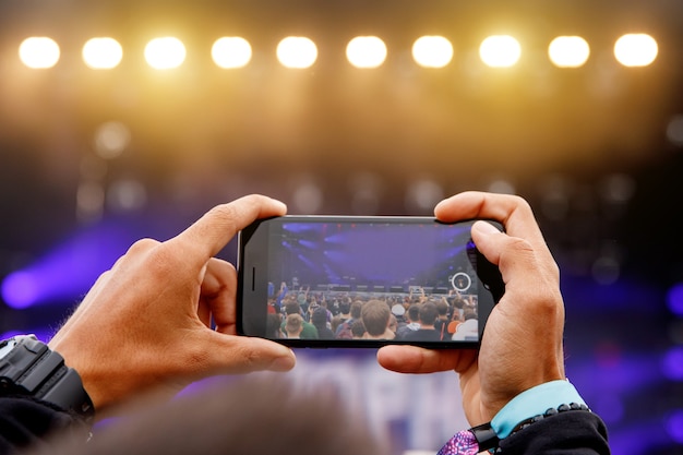 Video of foto maken tijdens een concert. Smartphone in handen.