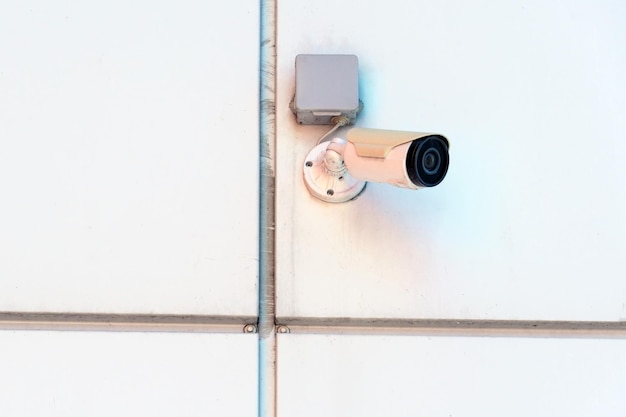 Video surveillance cameras installed on the white wall at the\
entrance to the supermarket security and antitheft systems\
protection of personal property and protection of private\
territory