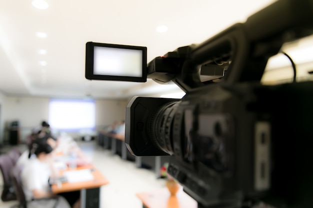 Videocamera in deelnemers aan de vergaderruimte van de zakelijke conferentie en hoofdtelefoon