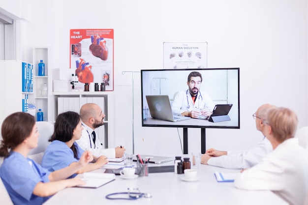 Videoconference of hospital team with expert doctor. Medicine staff using internet during online meeting with therapist doctor for expertise.