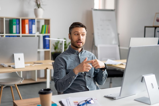 Videoconferentieportret van een volwassen zakenman die een webgesprek voert met behulp van een moderne computer terwijl hij zit